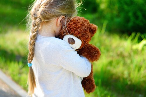 Meisje dat haar teddybeer knuffelt