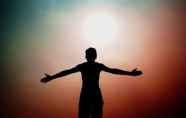 Man die met open armen richting de zon staat, als voorbeeld van de persoonlijkheidstypes volgens Erich Fromm