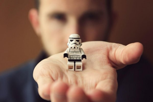 Man met lego-poppetje op zijn hand
