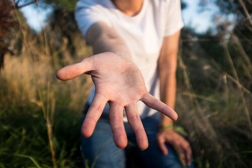 Man die zijn hand naar iemand uitreikt, als voorbeeld van filantropie