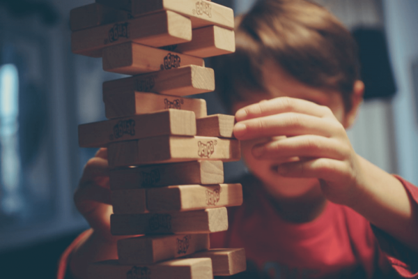 Kind dat in zijn eentje zit te spelen, want mensen hebben vaak een negatief beeld van kinderen met leerproblemen