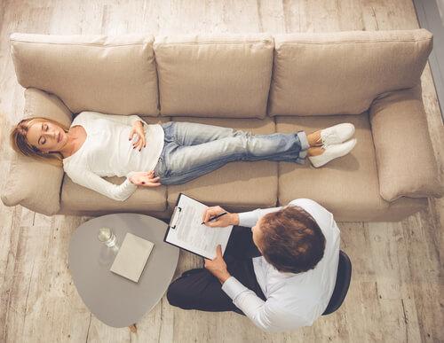 Vrouw die op de bank ligt tijdens een therapiesessie, maar wat zijn de verschillen tussen Freud en Jung