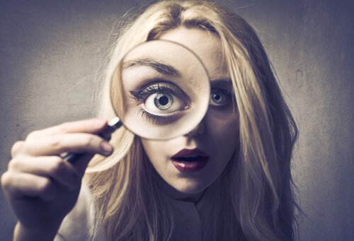 Meisje dat zichzelf bestudeert met een vergrootglas omdat ze te zelfkritisch is