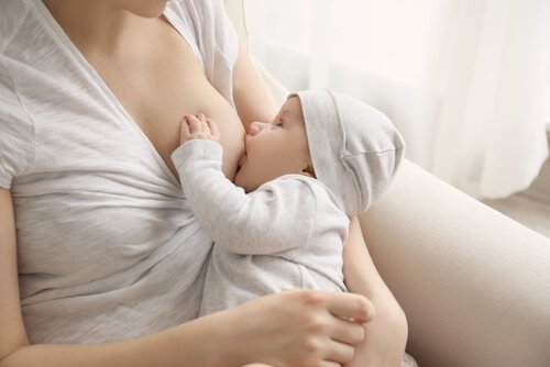 Moeder die haar baby bostvoeding geeft en allerlei postnatale emoties ervaart