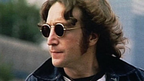 John Lennon draagt ​​een donkere bril.