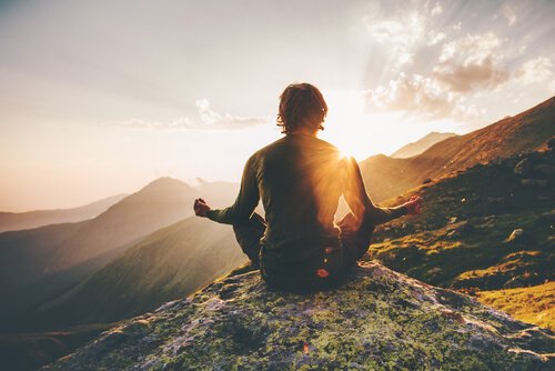 Een man die mediteert op een berg