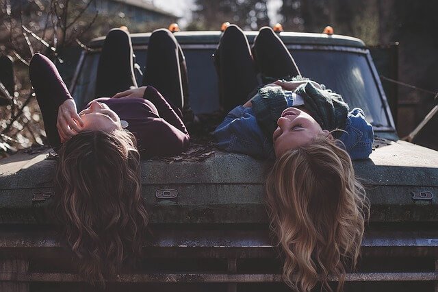 Twee vriendinnen op een auto