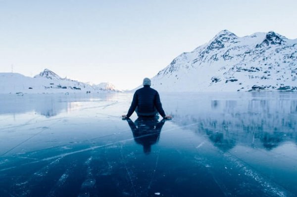 Een man zit op het ijs