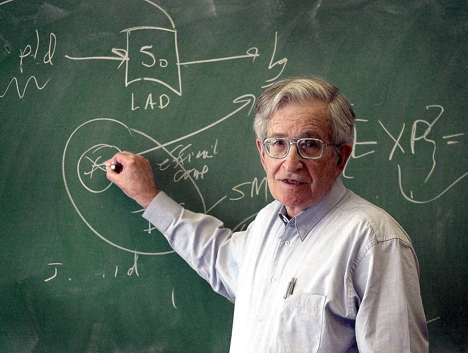 Noam Chomsky die op een bord schrijft