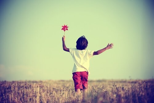 Jongetje dat vrij door een groot veld rent omdat zijn moeder niet een van de overbeschermende supermoeders was