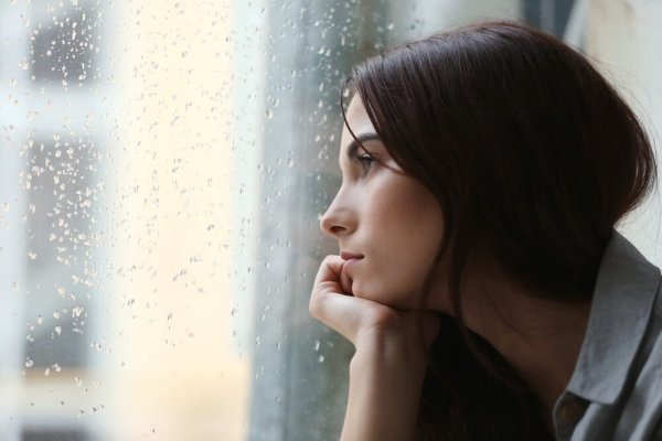 Verdrietige vrouw staart uit het raam