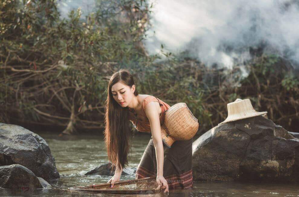 Vrouw die water haalt op een dag met donkere wolken