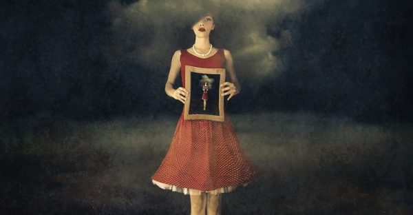 Meisje dat een portret in haar handen houdt en wil weten wat de kenmerken van emotionele volwassenheid zijn