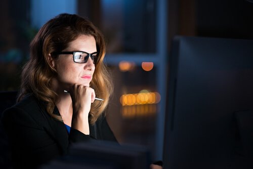Vrouw die 's nachts op de computer werkt