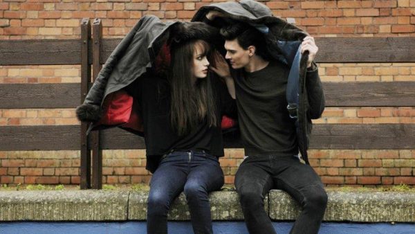 Stel schuilend onder een jas