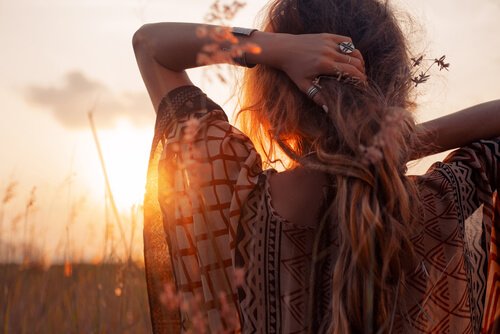 Vrouw die naar een zonsondergang kijkt in een open veld, want ze wil spontaner zijn