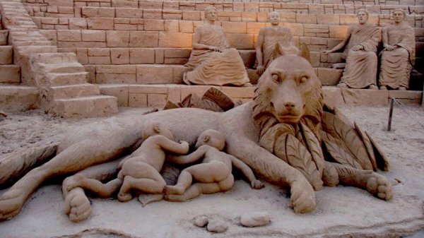 Standbeeld van twee wilde kinderen die naast een leeuw slapen