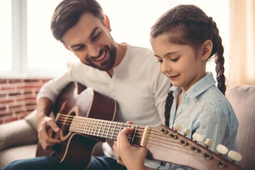 Vader leert kind gitaar spelen