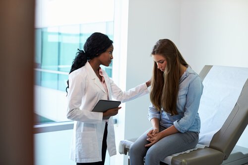 Arts praat met vrouwelijke patiënt