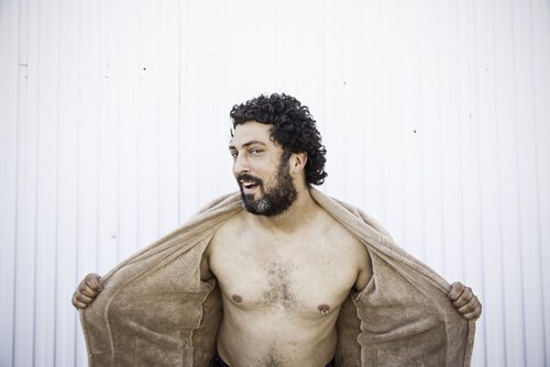 Een man opent zijn jas en toont zijn borstkas