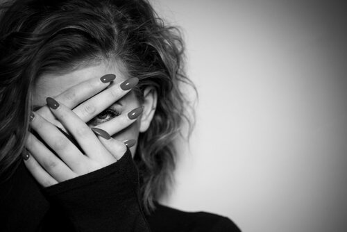 Vrouw die door haar vingers kijkt