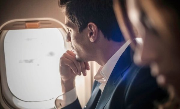 Man kijkt uit het raam van een vliegtuig