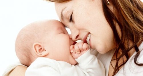 Moeder die bij baby glimlacht