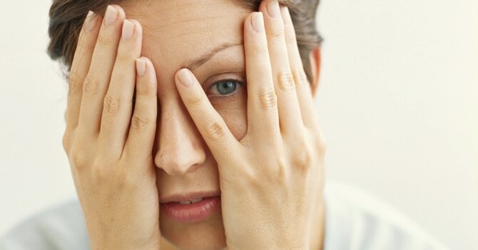 Vrouw met handen voor het gezicht