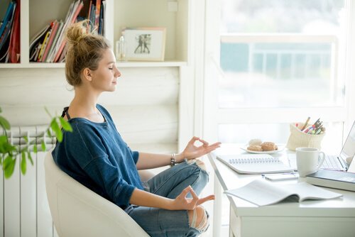 Vrouw mediteert achter haar bureau