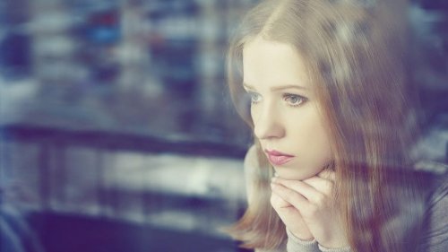 Vrouw kijkt uit het raam