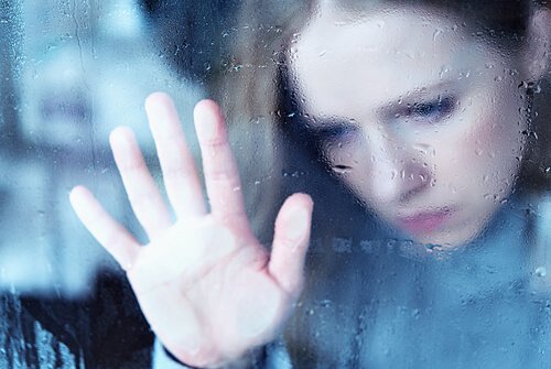 Verdrietige vrouw kijkt uit het raam