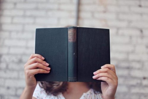 Vrouw bedekt haar gezicht met een boek