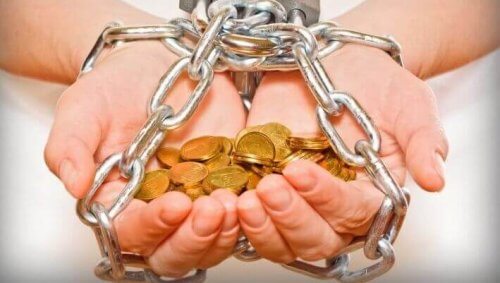 Geketende handen die geld vasthouden