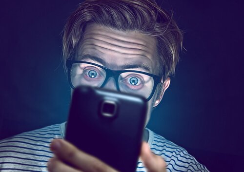 Men kijkt op het scherm van een mobiele telefoon