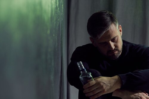 Dronken man met fles alcohol