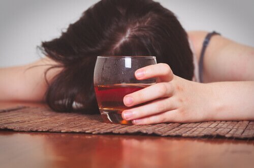 Dronken vrouw met glas alcohol in haar hand