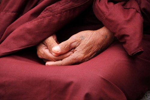 Handen van een mediterende oude man