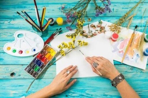 Vrouw met verf, kwasten en bloemen