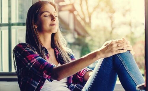 Vrouw zit tevreden in het zonlicht