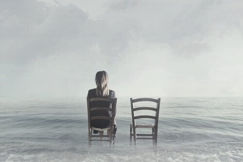 Vrouw op stoel in het water naast een lege stoel
