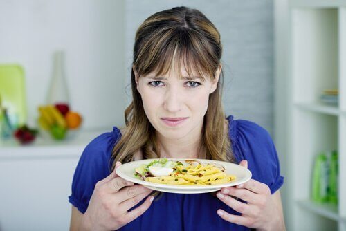 Vrouw walgt van bord eten