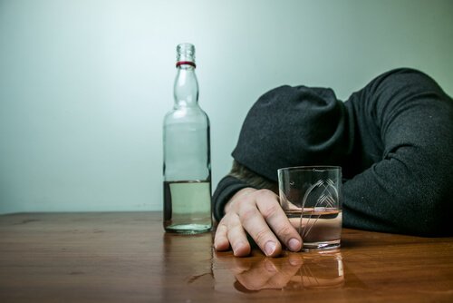 Dronken man ligt met zijn hoofd op tafel
