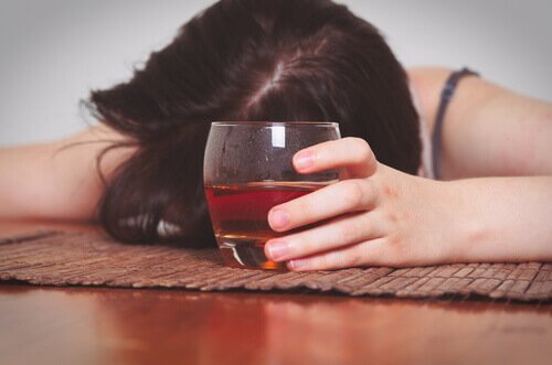 Dronken vrouw leunt op tafel