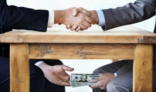 Twee mannen die geld overhandigen onder tafel