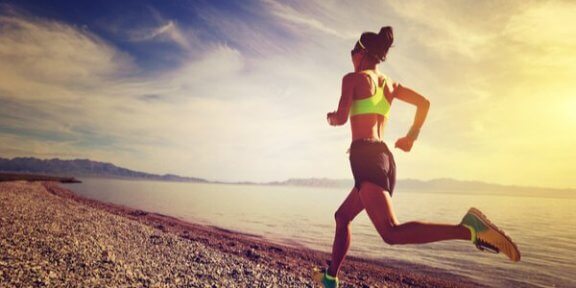 Vrouw die over het strand aan het hardlopen is