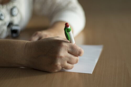 Persoon schrijft op een papier