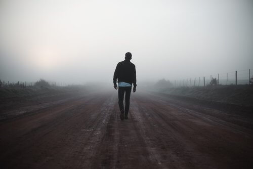Man die over verlaten weg loopt