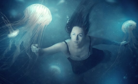 Vrouw zwemmend tussen kwallen