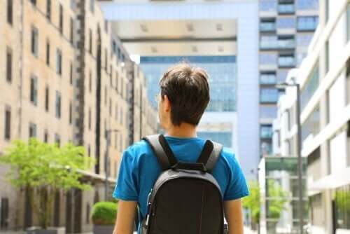 Man loopt met rugzak door een stad