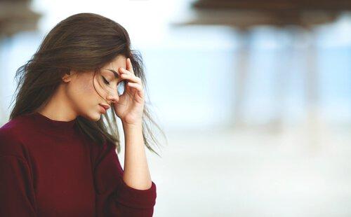 Vrouw houdt haar hand tegen haar voorhoofd